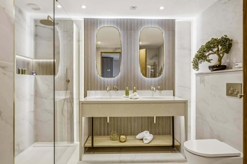 Elegant hotel bathroom with twin sinks, marble decor, rain shower, and luxury toiletries. Relax in tranquillity and style.