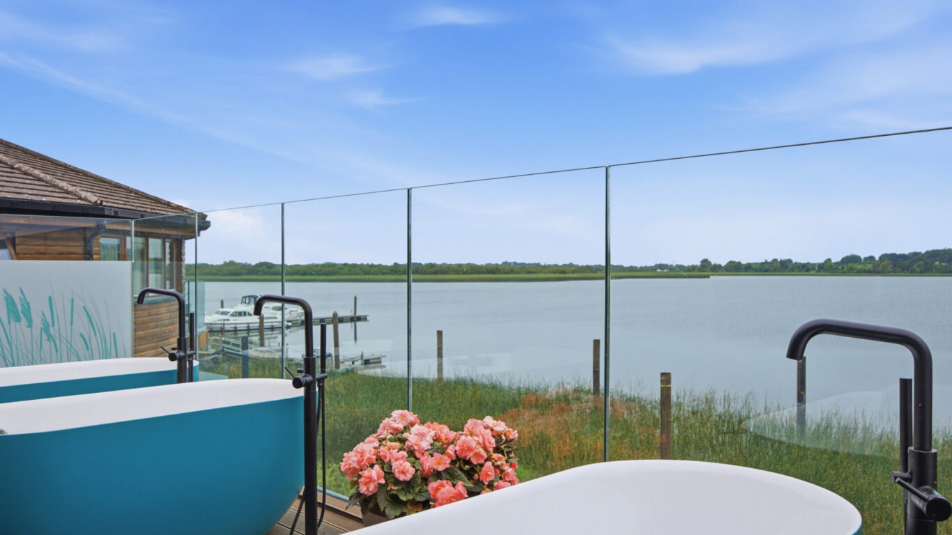 Relax in outdoor tubs overlooking a serene lake, surrounded by nature and luxury amenities at our stunning hotel.